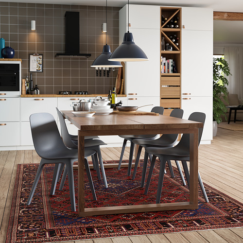 Modern kitchen with MÖRBYLÅNGA oak dining table, gray chairs, black pendant lamps, white cabinets, and dark red rug.