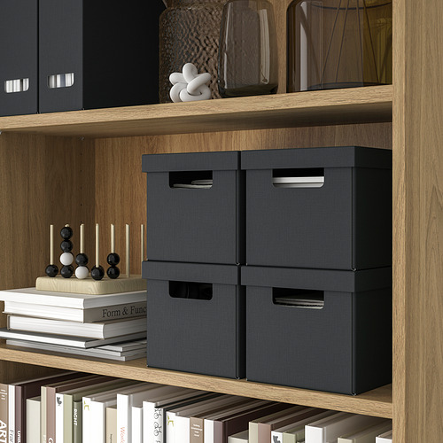 Estantes de madera con cajas de almacenamiento negras, artículos decorativos y libros. Cajas ideales para pequeños accesorios, fotos y cordones.