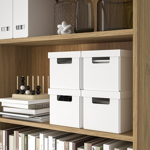 Estante de madera con cajas de almacenamiento blancas, artículos decorativos y libros, perfecto para organizar artículos pequeños.