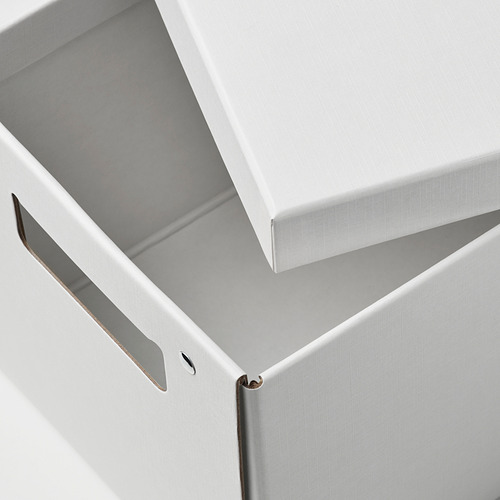Caja de cartón blanca cerrada, cuidadosamente elaborada con cierre de metal visible, asentada sobre una superficie plana.