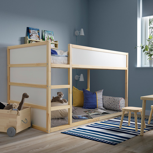 Habitación infantil con litera de madera, peluches, almohadas a rayas, paredes azules y una alfombra. Las almohadillas BÄNKKAMRAT se colocan debajo para mayor comodidad y seguridad.