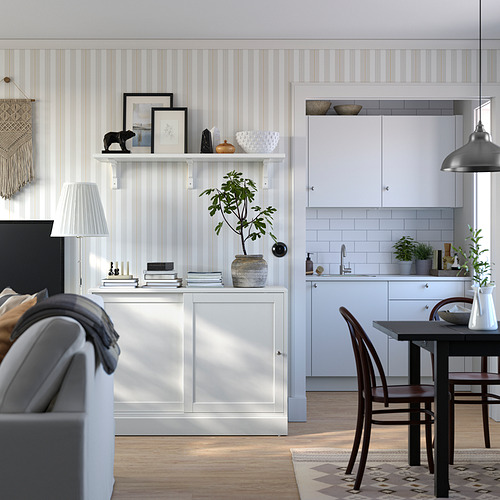 Cocina y sala de estar modernas con aparador HAVSTA en pino blanco, con diseño escandinavo, puertas correderas y elementos decorativos.
