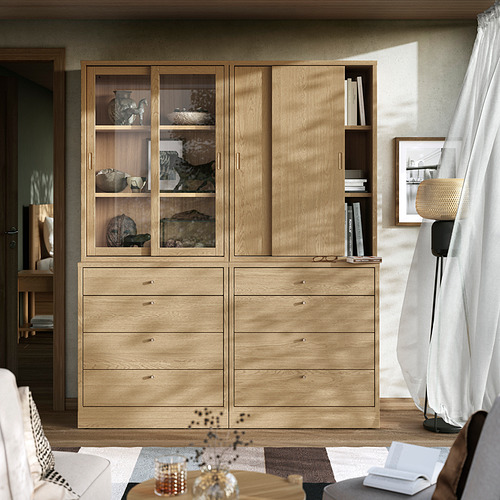 Muebles de madera en sala de estar con vitrina, estanterías y libros.