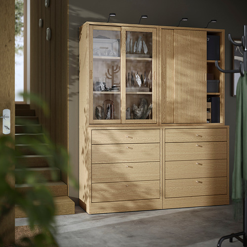 Mueble TONSTAD de madera con cajones y puertas de cristal, de pie junto a las escaleras, diseño moderno-clásico.