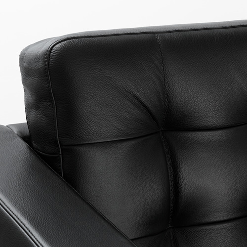 Rincón de muebles tapizados en piel negra. Acolchado liso y cosido. Artesanía detallada visible.