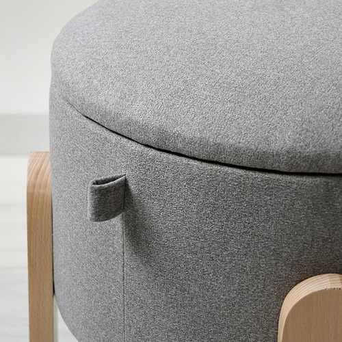 Taburete circular tapizado con tela gris, con asas de madera robustas y costuras de calidad.