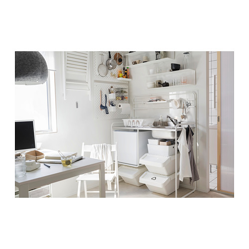 Mini cocina blanca moderna con fregadero, estante y accesorios organizados de acero inoxidable.
