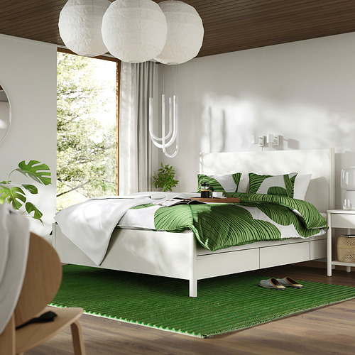 Cama TONSTAD con decoración verde, cajones de cierre suave, lámparas colgantes, plantas junto a la ventana.