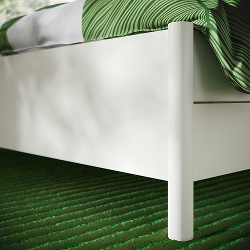 Cama blanca moderna con sábanas verdes