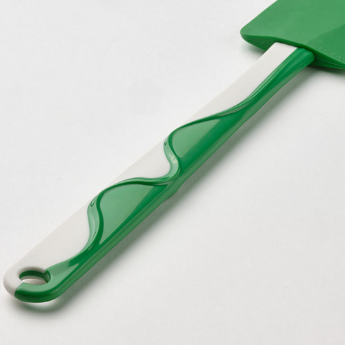 Espátula verde con patrón blanco, hoja flexible, mango ergonómico.