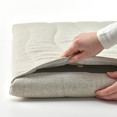 Persona levantando una pantalla acústica gris plegada, mostrando su funda desmontable y lavable.