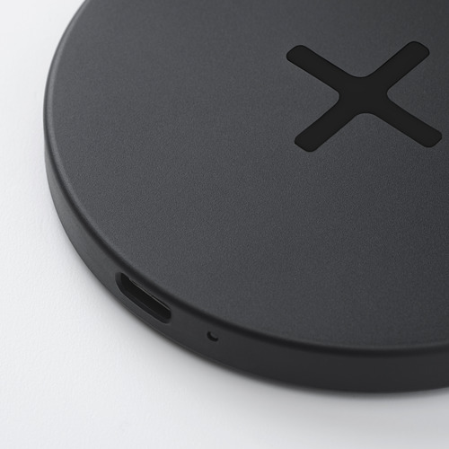 Almohadilla de carga inalámbrica negra con cruz, diseño elegante, puerto usb-c, pies de silicona.