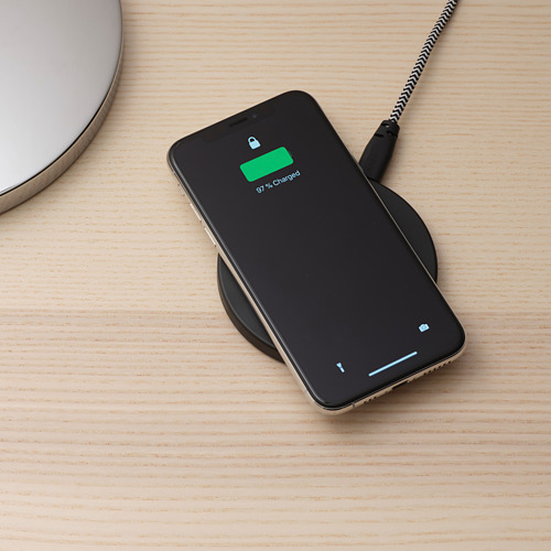 Un teléfono inteligente que se carga en una plataforma inalámbrica, que muestra un 97% de carga, con un cable usb-c conectado.