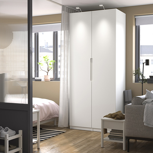 Moderno armario blanco PAX en un dormitorio luminoso y acogedor.