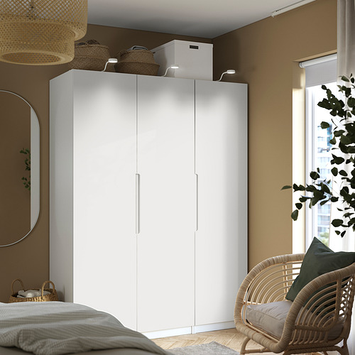 Dormitorio con gran armario TONSTAD blanco, silla de mimbre, banco y espejo.