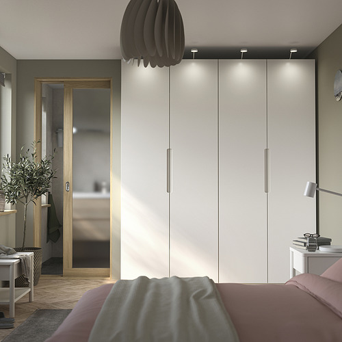 Dormitorio moderno con puerta TONSTAD en color blanco roto, armario, cama y mesa a juego. Diseño de bordes suaves, asas integradas. Garantía de 10 años.