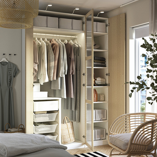 Dormitorio moderno con armario abierto, ropa organizada e iluminación integrada.