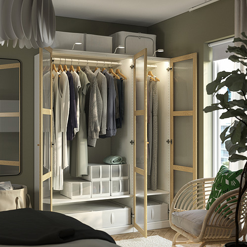 Moderno armario abierto con ropa, puertas transparentes, luz y cajas de almacenamiento.