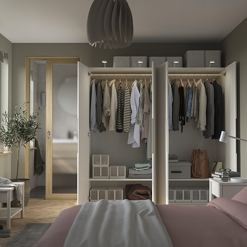 Dormitorio moderno con armario abierto PAX que exhibe ropa y almacenamiento.