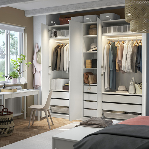 Dormitorio moderno con armario abierto, ropa organizada e iluminación integrada.