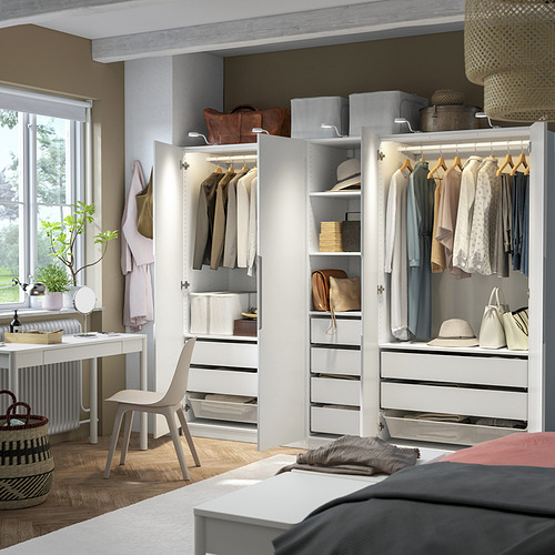 Dormitorio moderno con armario abierto PAX que exhibe ropa, estantes y cajas de almacenamiento.