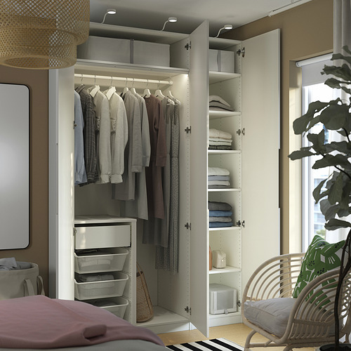 Armario PAX organizado con ropa plegable, toallas apiladas y cestas de malla.