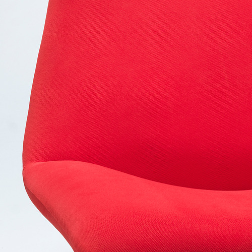 Silla tapizada en rojo brillante en primer plano. Tejido suave y liso y diseño curvo.