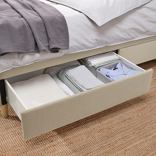 Cama con cajón abierto que muestra sábanas cuidadosamente dobladas; Función de cierre suave visible.