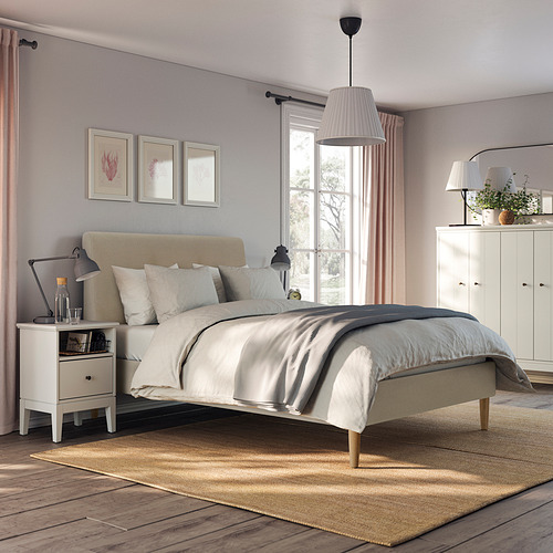 Dormitorio moderno y minimalista con cama IDANÄS, tela beige. Cabecero grande e inclinado, patas de madera. Mesita de noche y armario de cortesía.