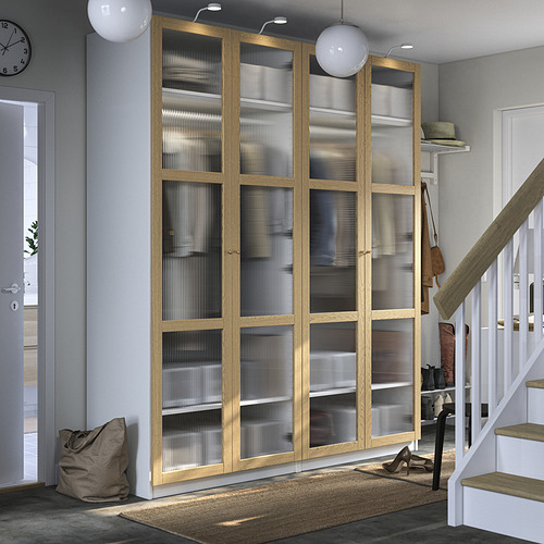 Armario PAX de madera con cristal esmerilado en habitación gris. Cerca de escaleras, con alfombra y decoración.