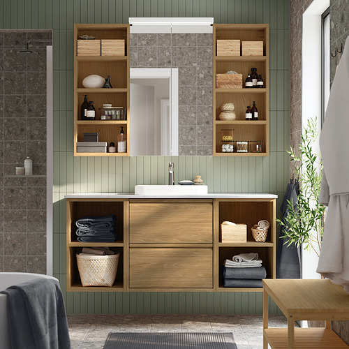 Baño moderno con armario de hagån de madera clara sobre el lavabo, con capacidad para toallas y botellas.