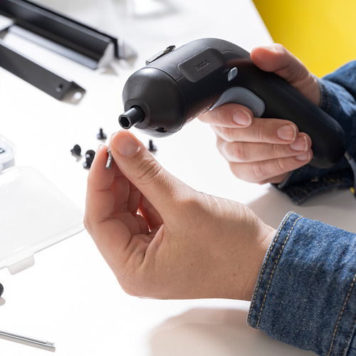 Persona sosteniendo un destornillador inalámbrico TRIXIG, demostrando su portapuntas magnético y su diseño ergonómico.