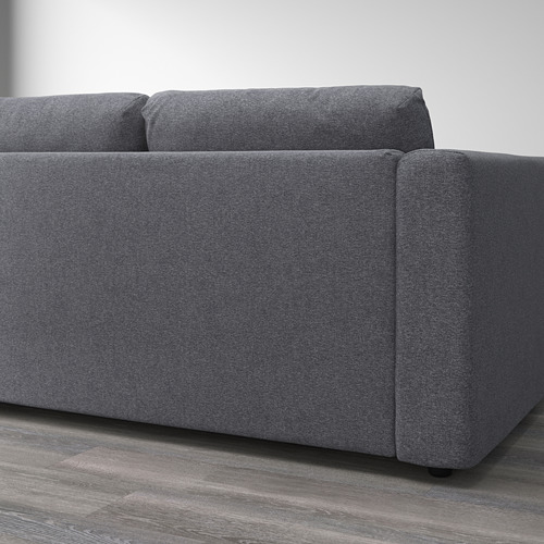 Primer plano de un sofá modular de esquina VIMLE sobre suelo de madera que muestra su tejido extraíble y lavable a máquina y su diseño robusto.