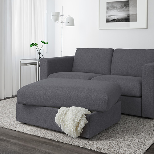 Sala de estar moderna con sofá seccional gris y reposapiés de almacenamiento. Fastidioso debajo del asiento, manta acogedora.