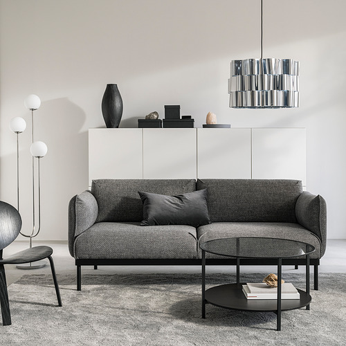 Salón moderno con sofá ÄPPLARYD gris, mesa de centro negra, armario blanco, lámpara colgante negra y lámpara de pie.