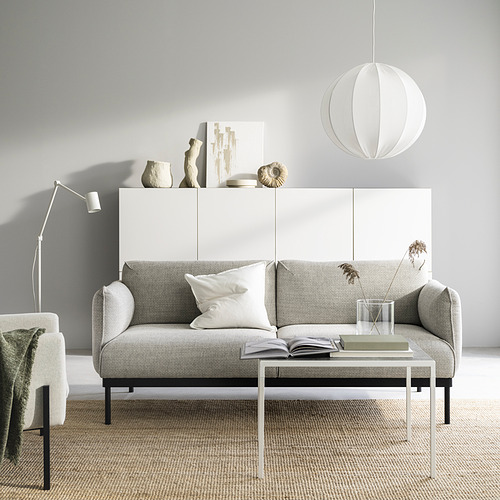 Sala de estar moderna y minimalista con sofá ÄPPLARYD gris, detalles en blanco y muebles elegantes.