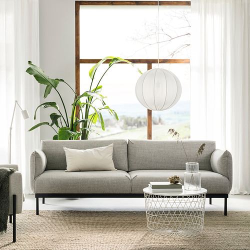 Sala de estar moderna con sofá gris ÄPPLARYD, almohadas blancas, mesa de centro de vidrio, gran planta verde y lámpara colgante.