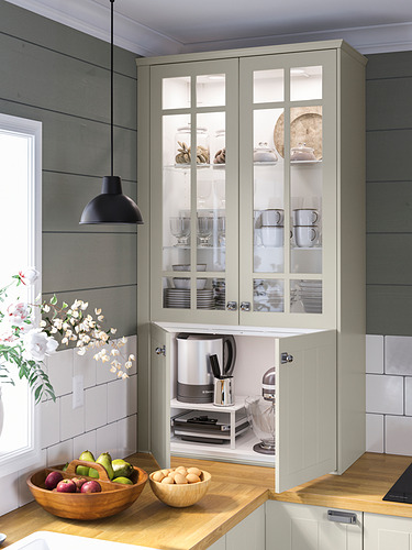 Cocina moderna con luz MITTLED, blanca. Vitrina exhibe platos. El mostrador de madera sostiene fruteros.