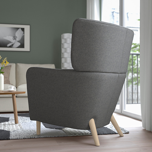 Moderno sillón orejero gris con patas de madera en acogedora habitación, que brinda comodidad con respaldo alto y reposabrazos.