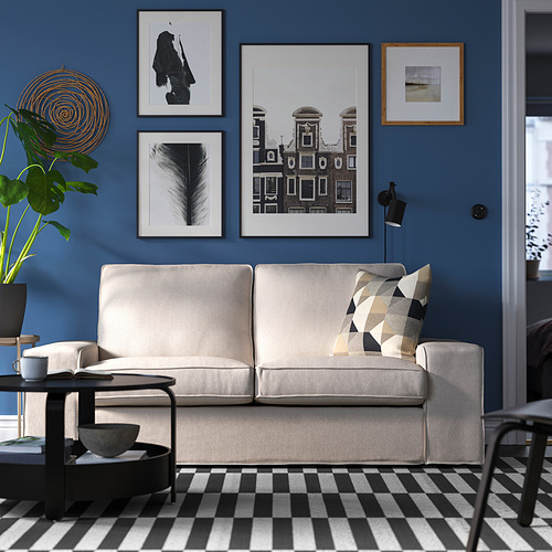 Sala de estar moderna con sofá KIVIK, alfombra a cuadros, paredes azules y arte mural.
