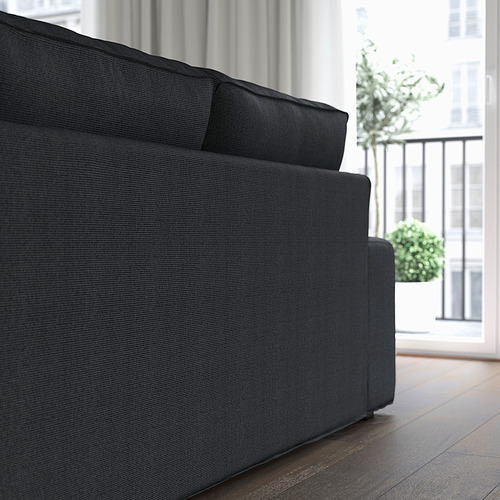 Sofá moderno negro con reposabrazos bajos, ideal para relajarse y socializar.