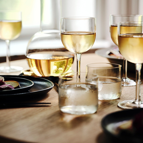 Seis copas de vino soplado a boca sobre mesa de madera con vino blanco. Elegante y estable para cualquier ocasión.