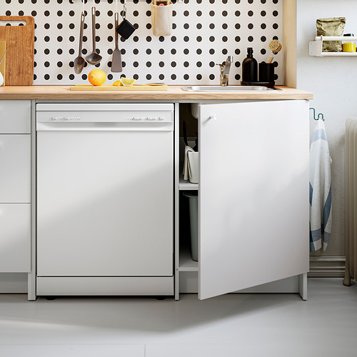 Cocina moderna con lavavajillas abierto, encimera de madera y placa para salpicaduras de lunares. Varias herramientas y utensilios de cocina organizados ordenadamente.