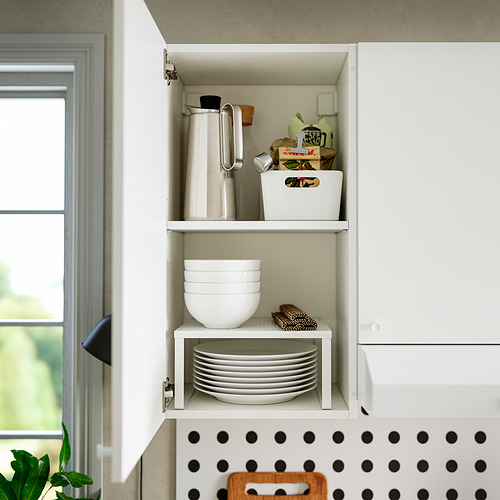 Gabinete de cocina abierto que muestra tazones, platos y artículos de cocina en estantes.