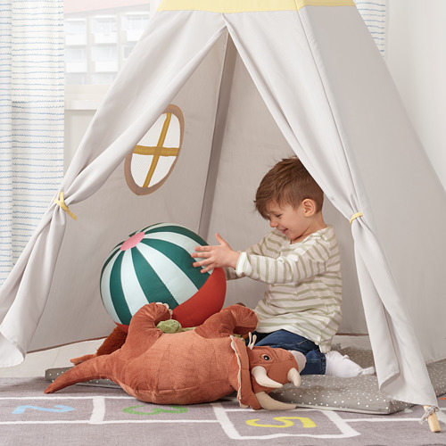 Niño en tienda de campaña con pelota y mamut de juguete.