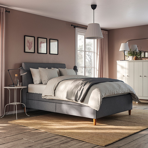 Cama moderna tapizada en color gris con cabecero inclinado, patas de madera y cajones de almacenaje incorporados.