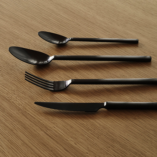 Cuatro cubiertos modernos colocados cuidadosamente sobre una superficie de madera. Acabado en acero inoxidable oscuro, diseño elegante.