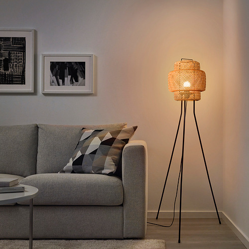 A cozy living room with SINNERLIG floor lamp, warm glow, and woven bamboo design.