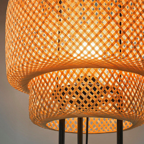 Two tiered bamboo pendant lamps, intricately woven, casting warm light.