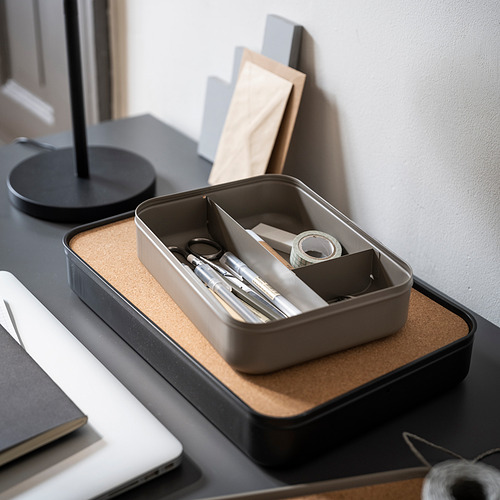 Organizador de escritorio gris de corcho y metal con compartimentos, que contiene suministros de oficina.